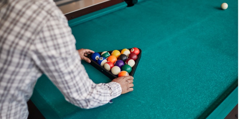 Person preparing pool balls for a game of pool